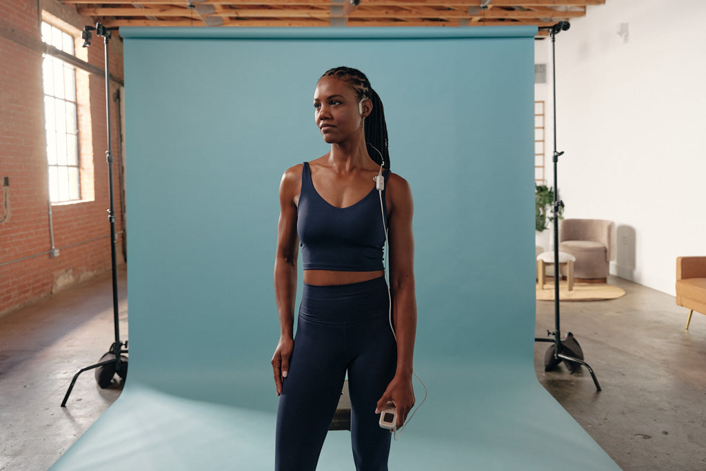 woman wearing ohmbody against a blue backdrop in a photography studio